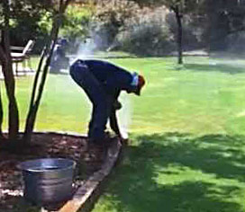 a Carmichael tech is checking a sprinkler